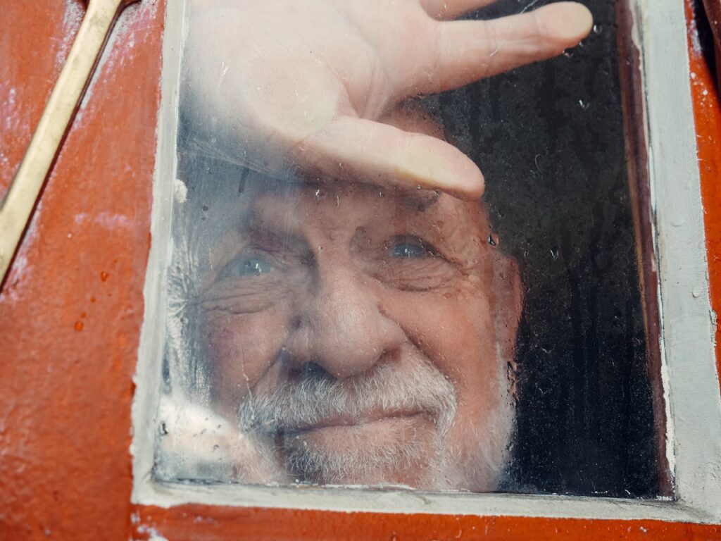 Old man looking out of a window